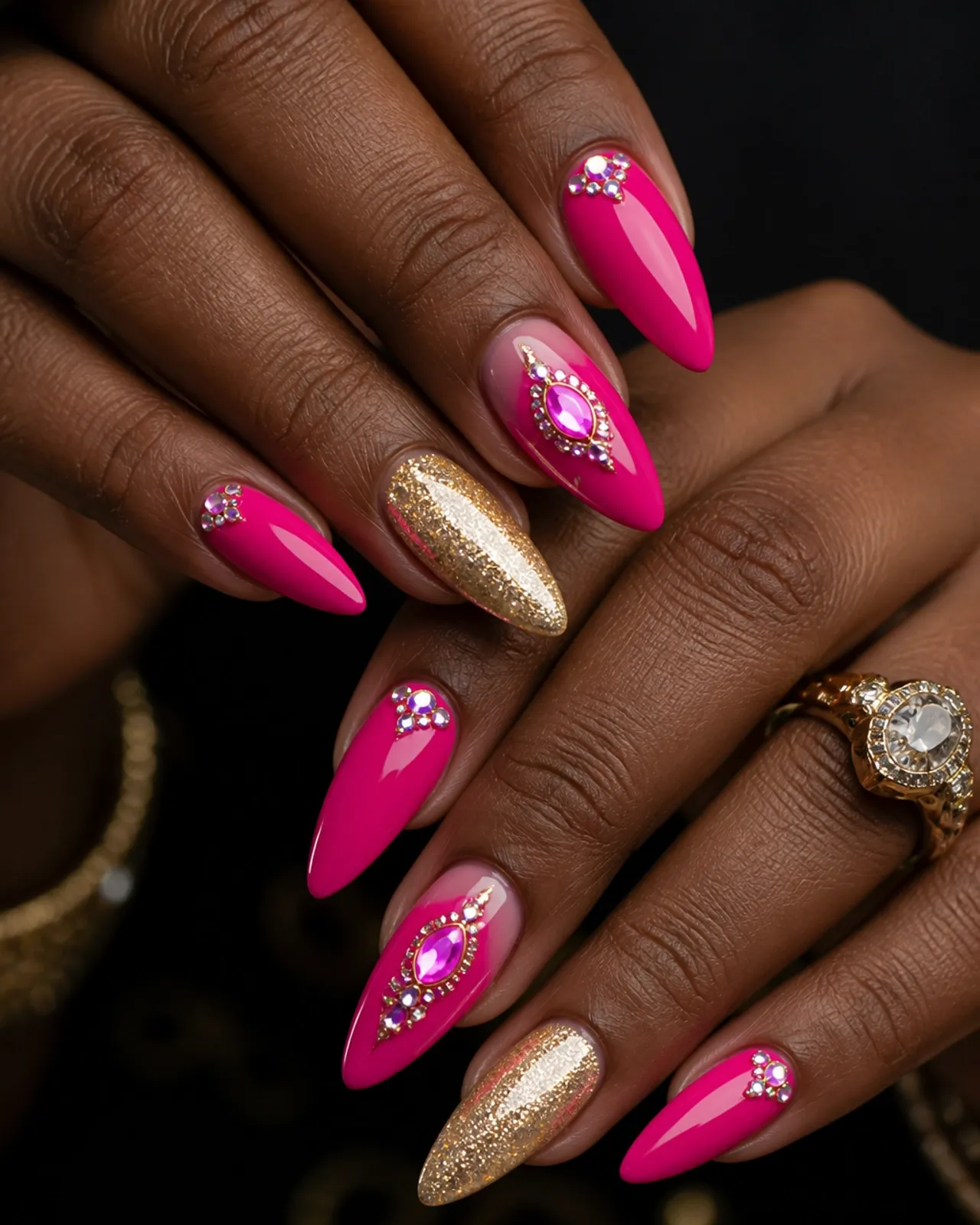Custom hot-pink and champagne acrylic nail art with rhinestone accents